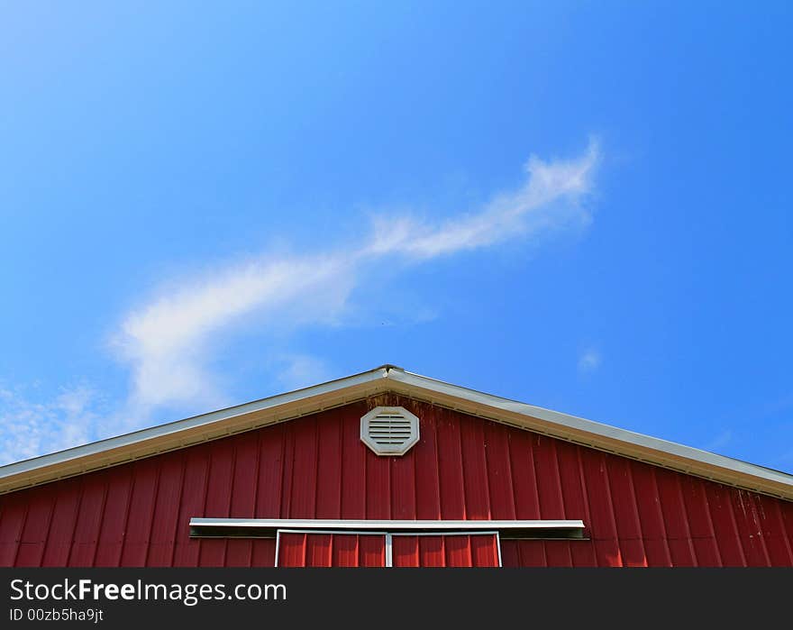 The roof a barn with a bright blue sky in the background. The roof a barn with a bright blue sky in the background