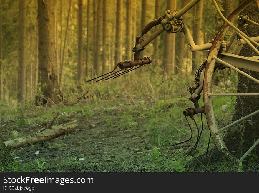 Old machine for ploughing standing in the forest