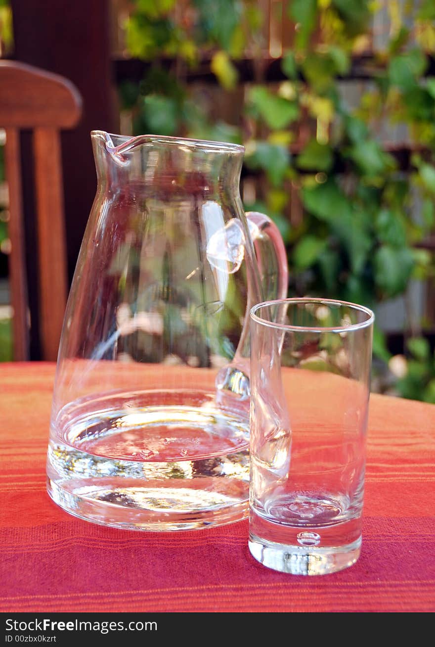 Close up of decanter and glass with water standing on table. Close up of decanter and glass with water standing on table.