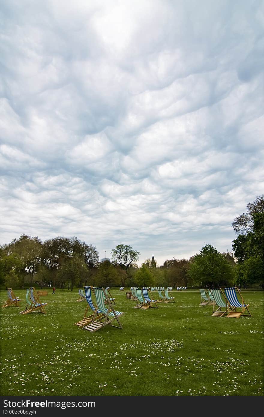 Empty deck chairs under dramatic cloudscape