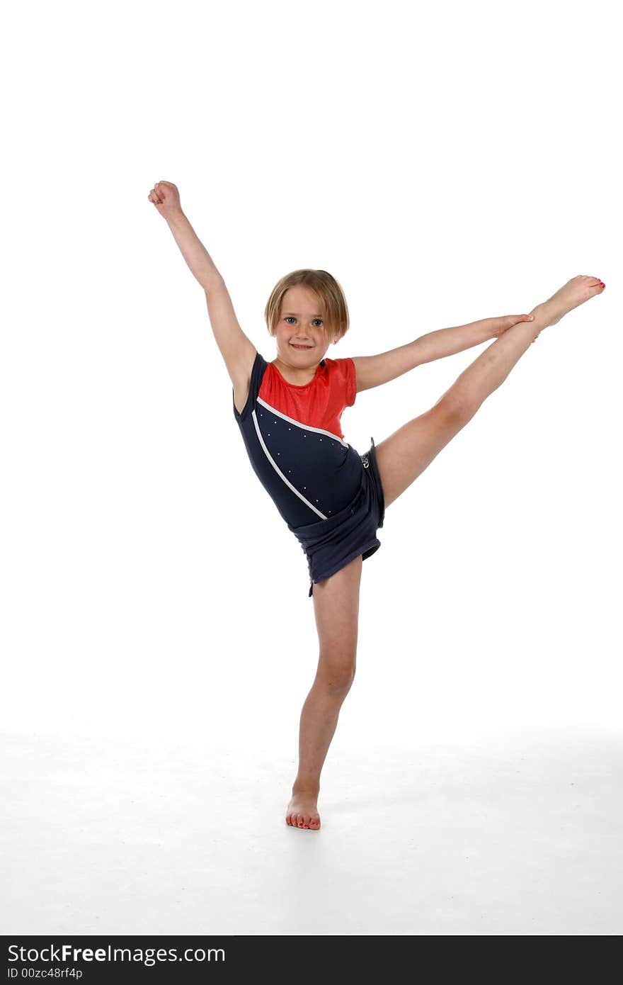 Young girl balancing on one leg with the other one up in the air.