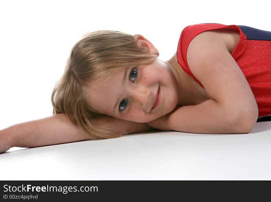 Young girl with a freckled face lying on her side with one arm out stretched