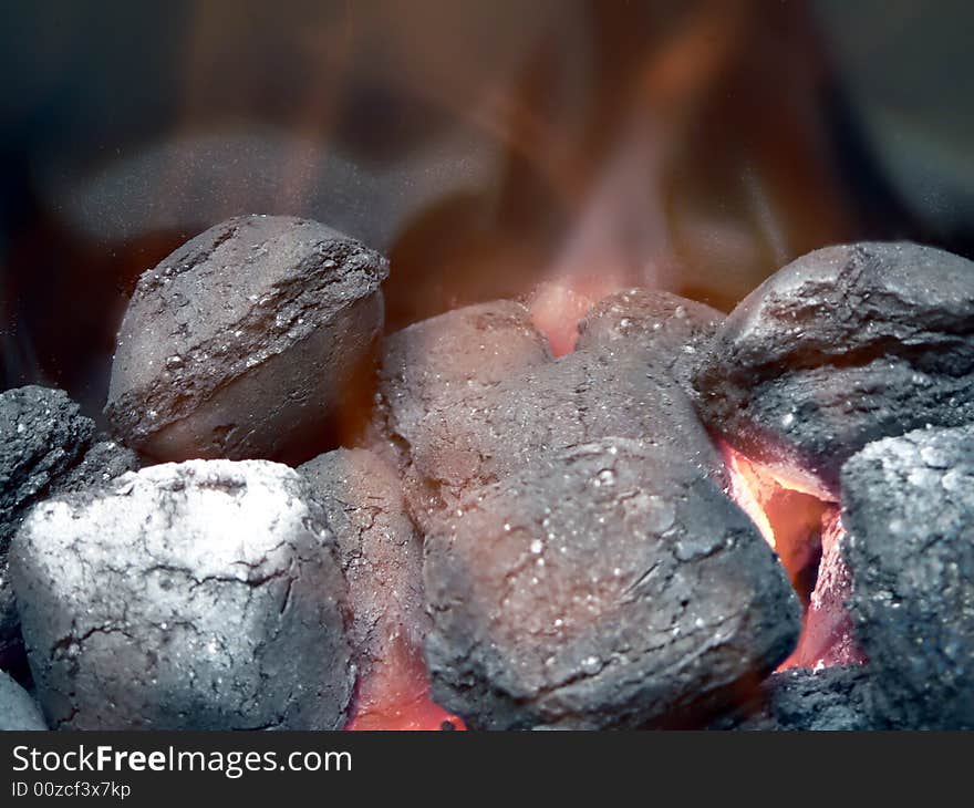 Close up view of smoldering charcoal  in flames for use in a barbecue grill. Close up view of smoldering charcoal  in flames for use in a barbecue grill.