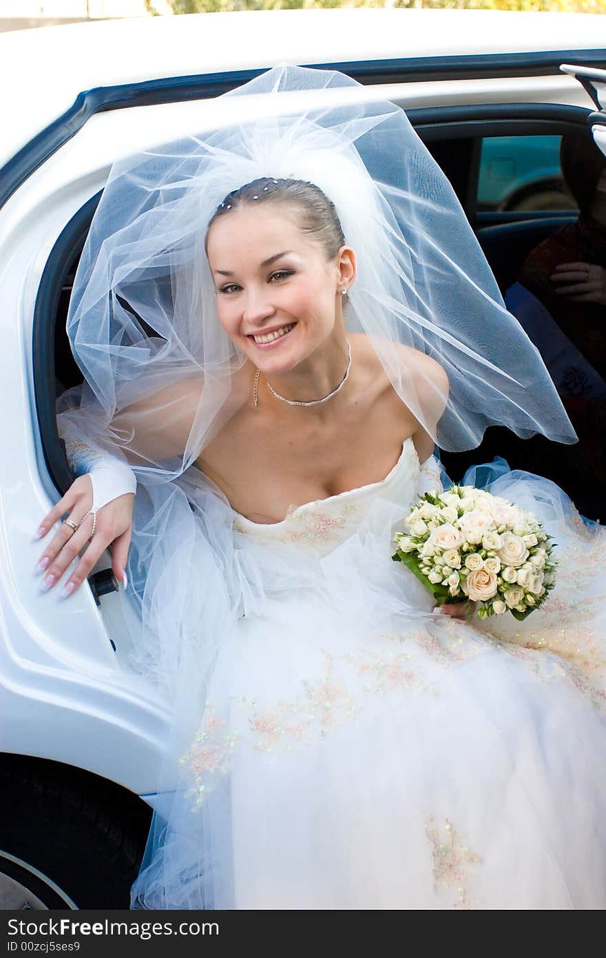 A bride leaves the car. A bride leaves the car