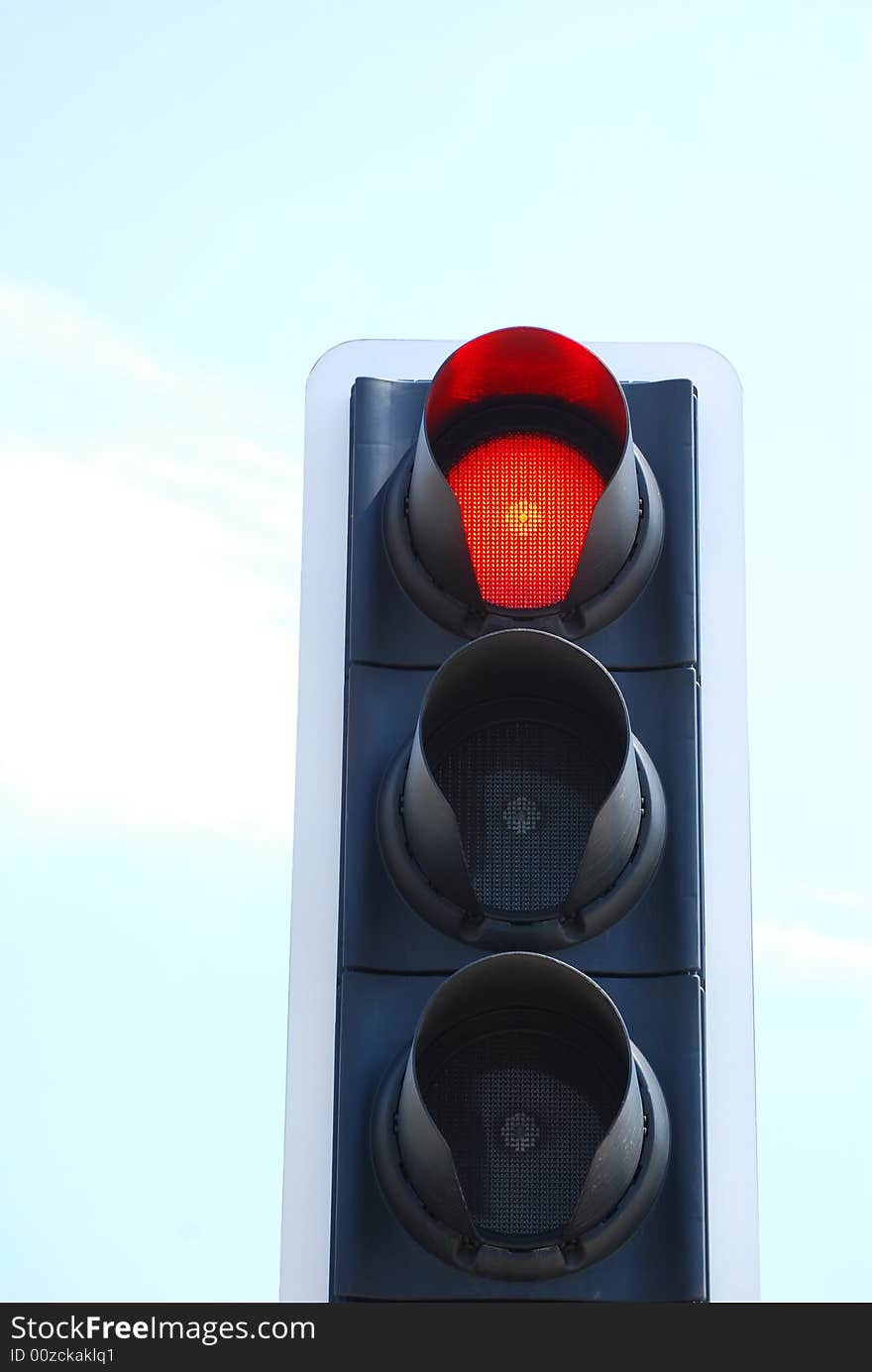 Red traffic light signal against cloudy blue sky. Red traffic light signal against cloudy blue sky