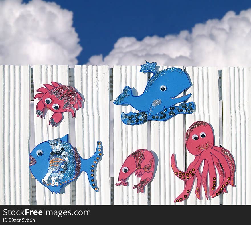 Little sea creatures made of moosgumy hung at the white fence. Little sea creatures made of moosgumy hung at the white fence