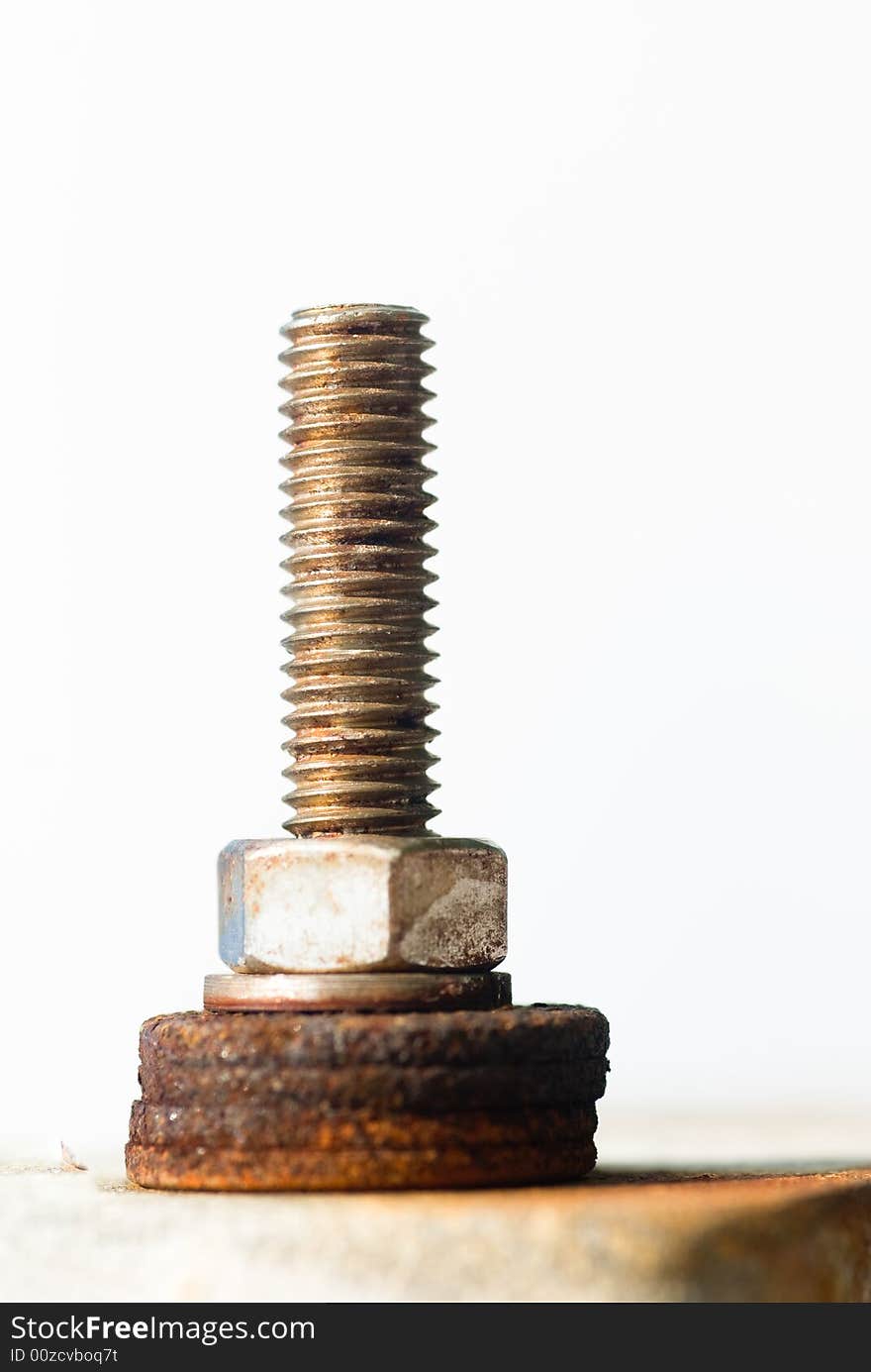 Attachment made of a threaded bolt and a nut atop a pile of rusty washers. Attachment made of a threaded bolt and a nut atop a pile of rusty washers