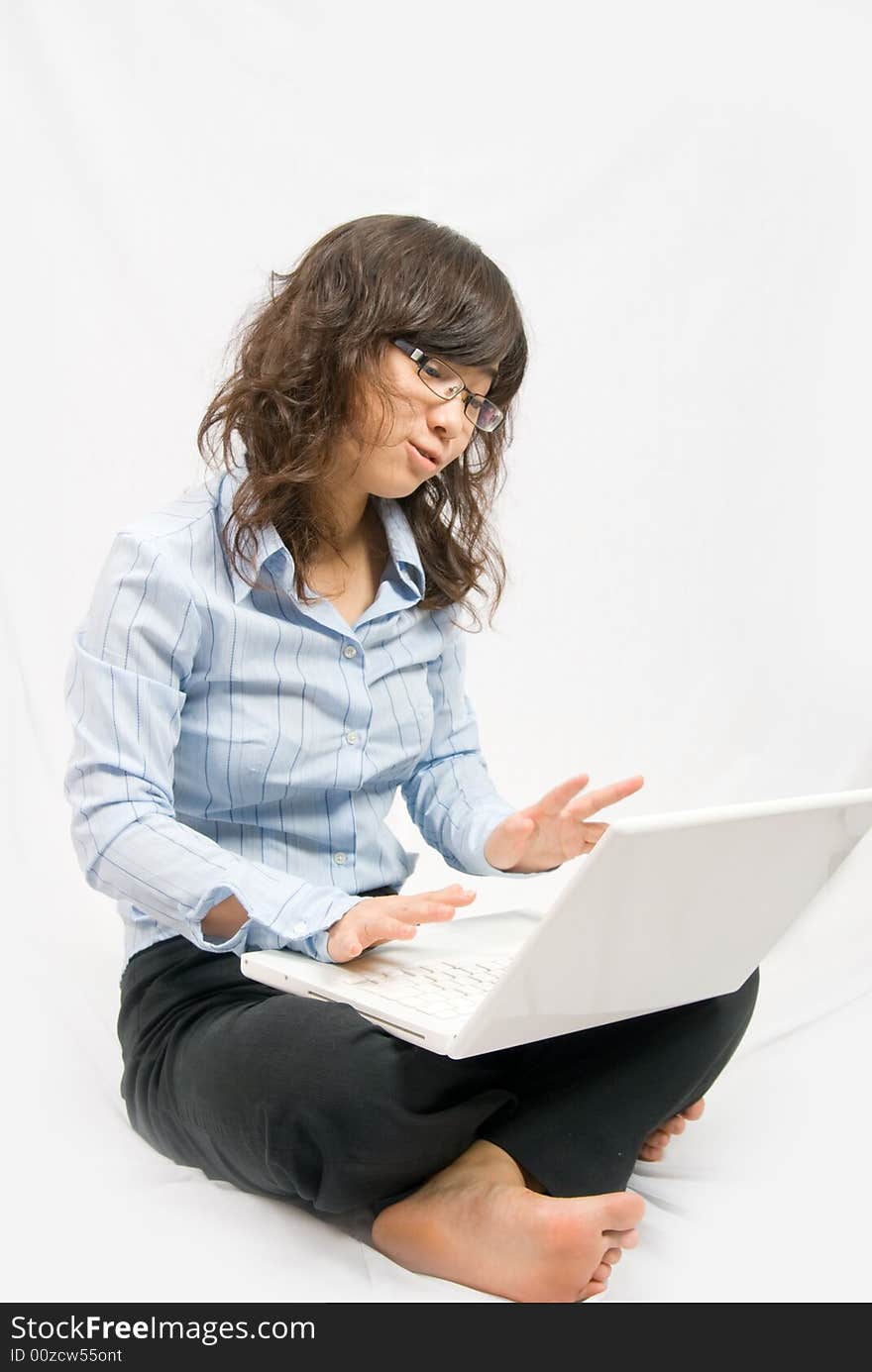 A young lady is working on a white notebook, typing some message. A young lady is working on a white notebook, typing some message.