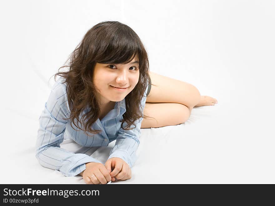 A young asian belle with knickers and light blue shirt lies on the white ground. A young asian belle with knickers and light blue shirt lies on the white ground