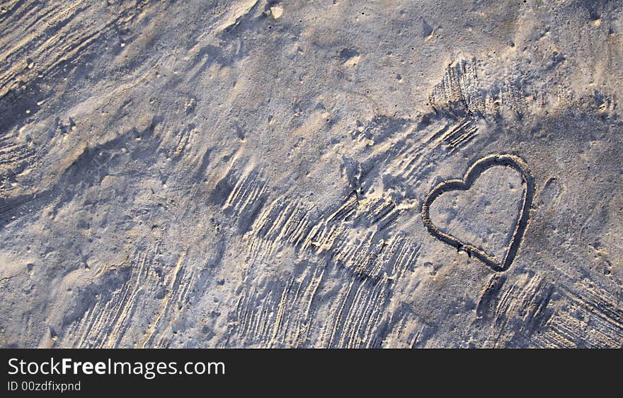 A heart shape in concrete in warm sunlight. A heart shape in concrete in warm sunlight