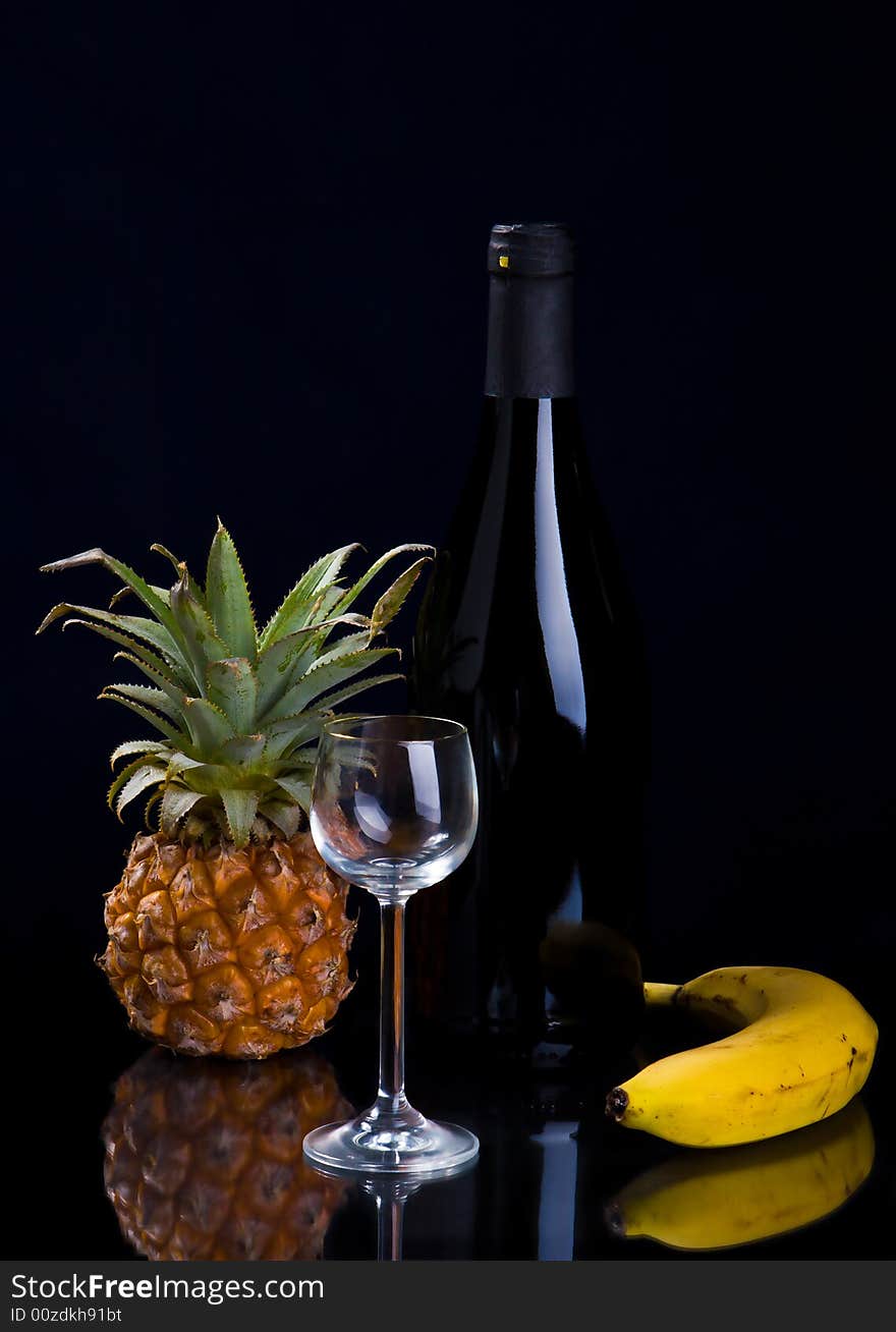 Fruit, a bottle and a glass on a black background. Fruit, a bottle and a glass on a black background