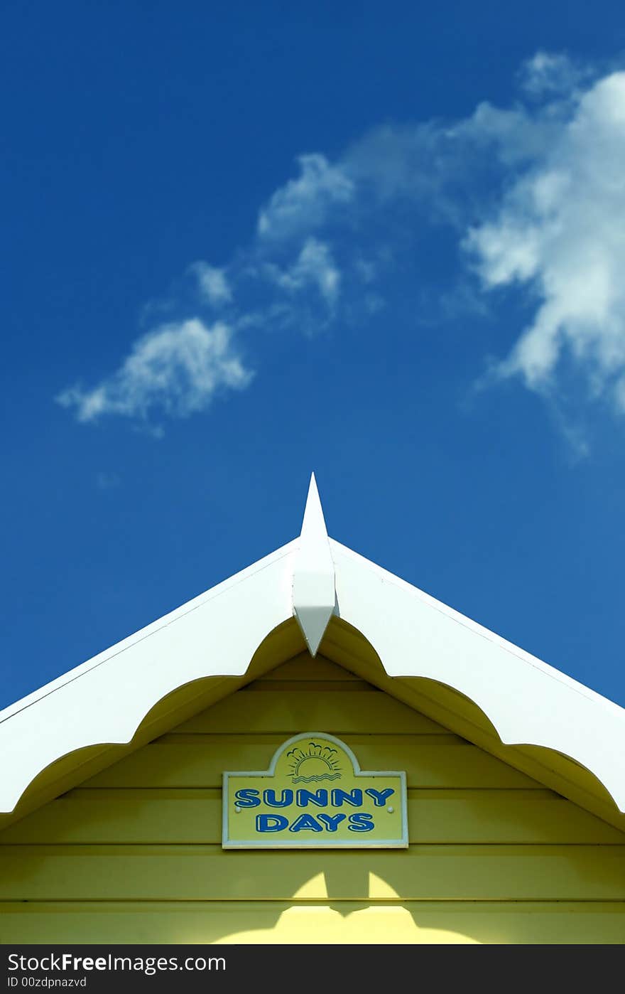 Roof line of a bright yellow beach hut with blue sky. Roof line of a bright yellow beach hut with blue sky