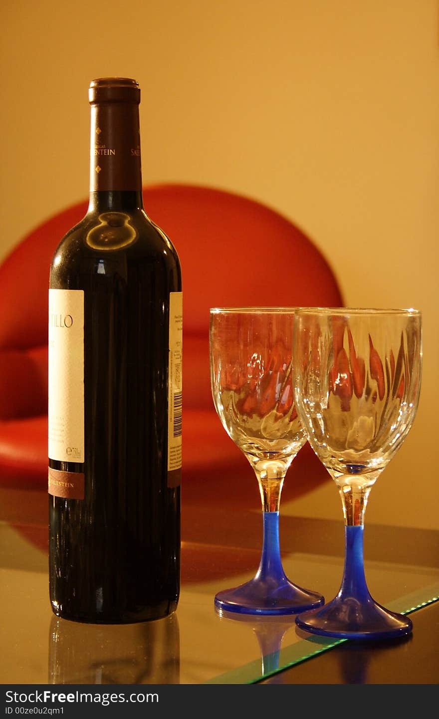 Two empty glass and a red wine bottle. Two empty glass and a red wine bottle.