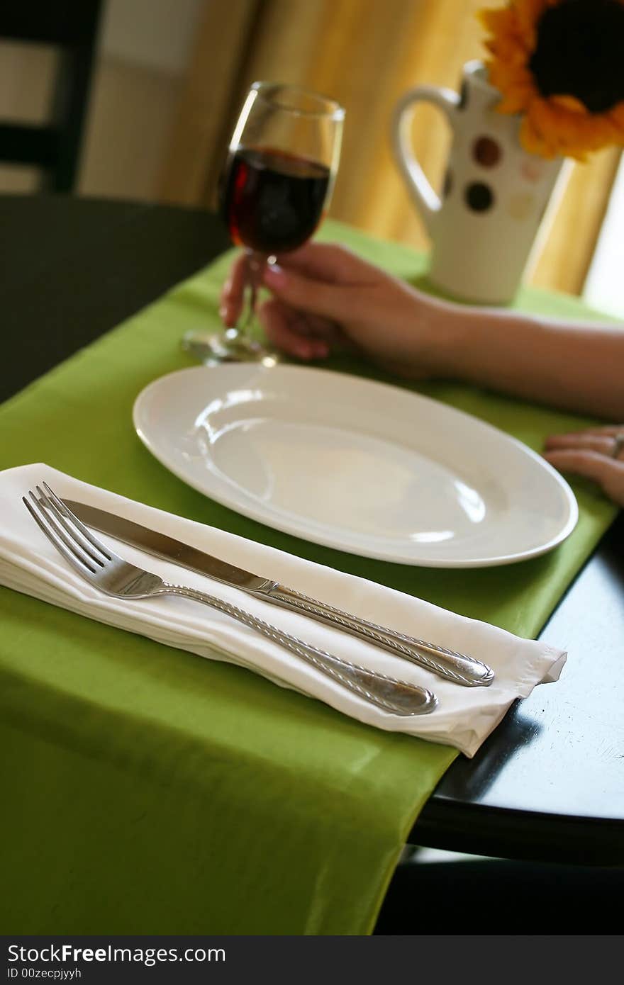 A woman drinks a glass of wine while waiting for dinner