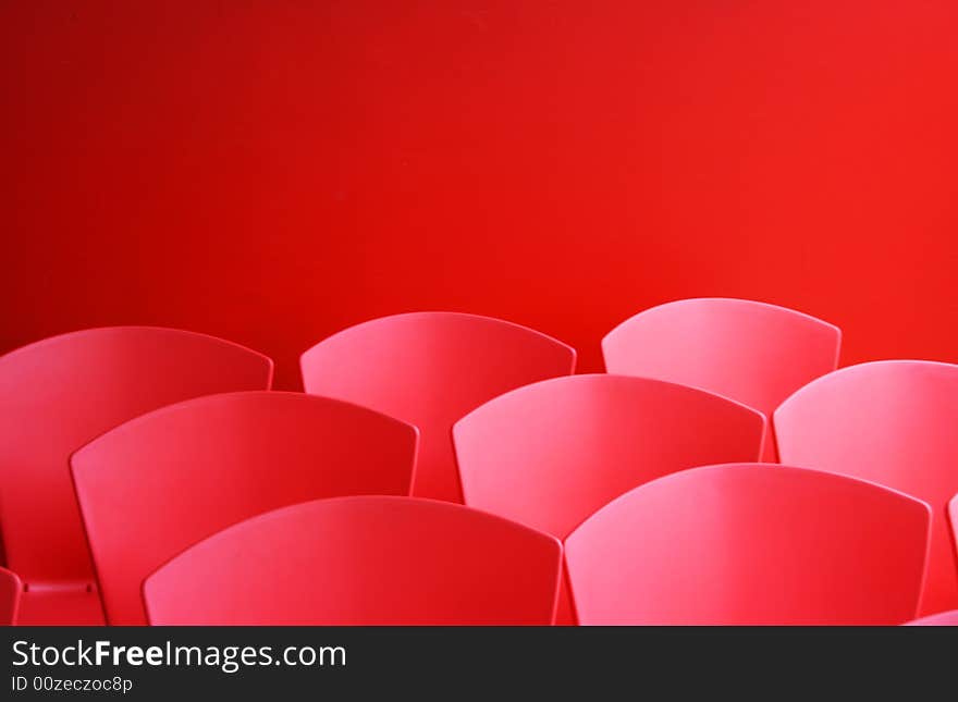 A groups of red chairs against a background of the same colour. A groups of red chairs against a background of the same colour