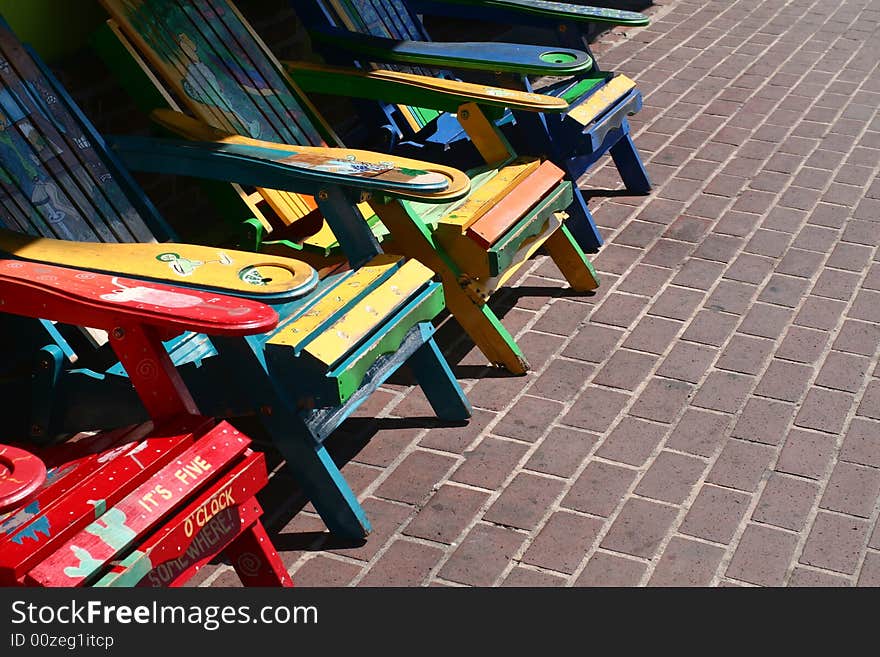 A group of very colorfully painted wooden chairs. A group of very colorfully painted wooden chairs.