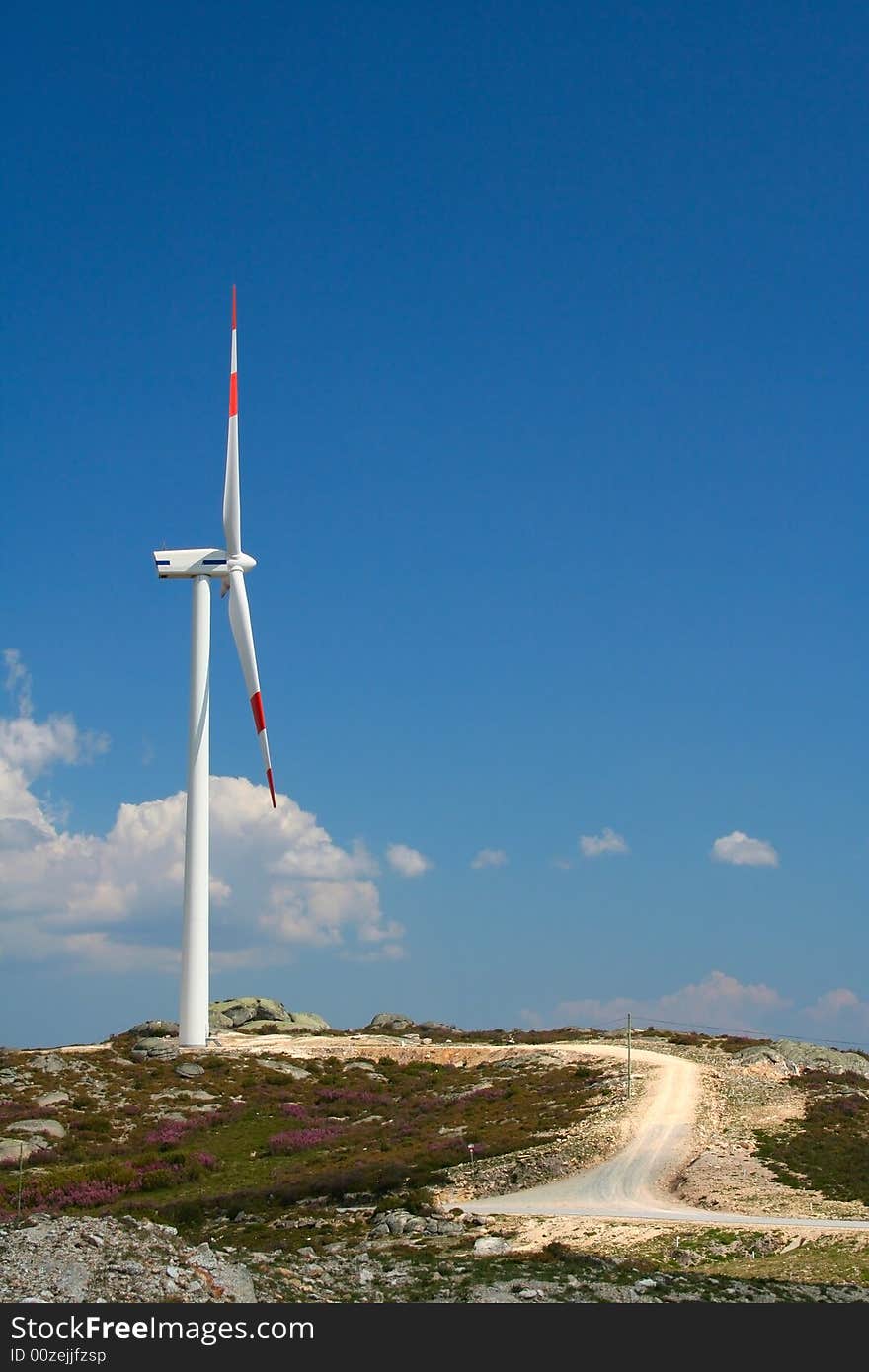 Wind turbine against blue sky.