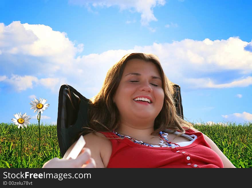 Teen girl at summer break, relaxing in beautiful green field with bright blue sky and shasta daises. Teen girl at summer break, relaxing in beautiful green field with bright blue sky and shasta daises.