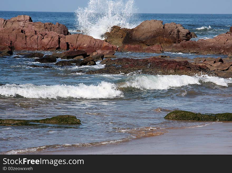 Waves breaking and crashing on the rocks on beach