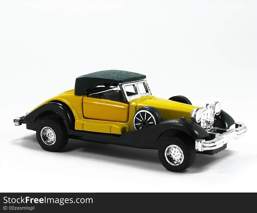 A isolated yellow and classic toy car. A isolated yellow and classic toy car.