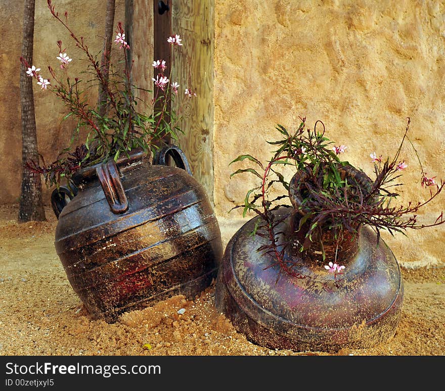 Two pots set in dry sand.