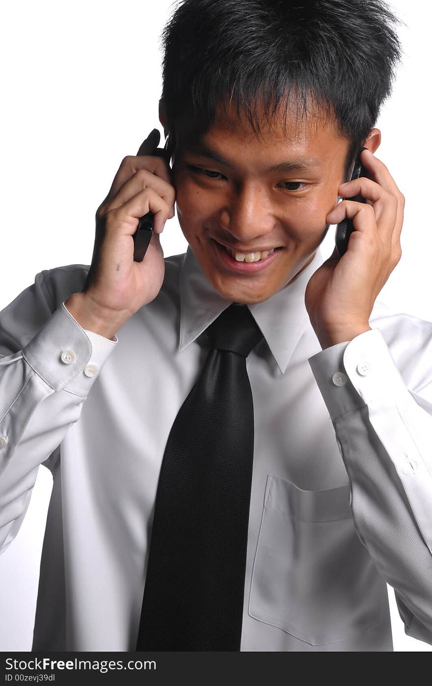 Asian business man conversing with multiple handphones. Asian business man conversing with multiple handphones