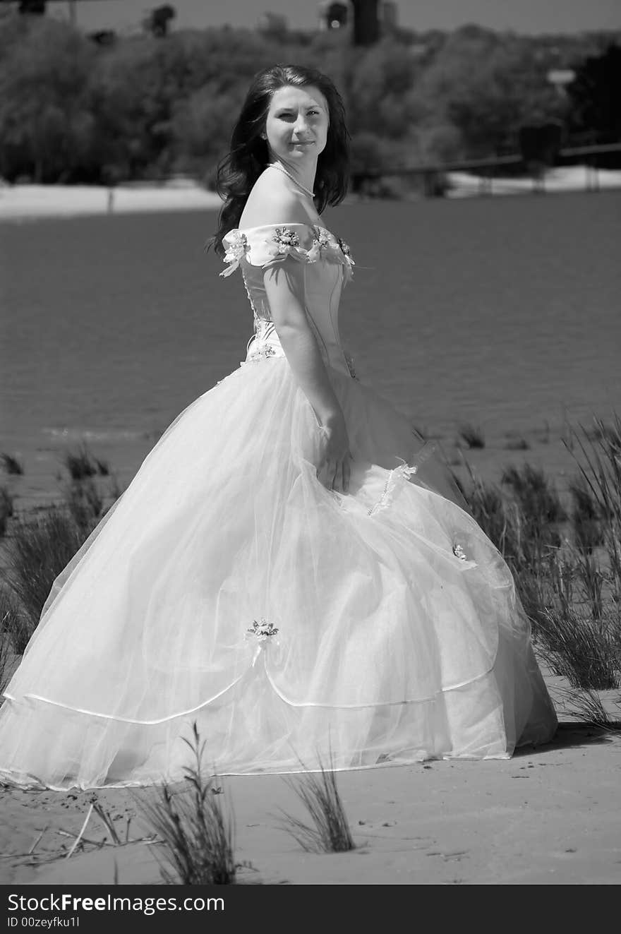 Bride on a sandy beach turns and look at cam. Bride on a sandy beach turns and look at cam