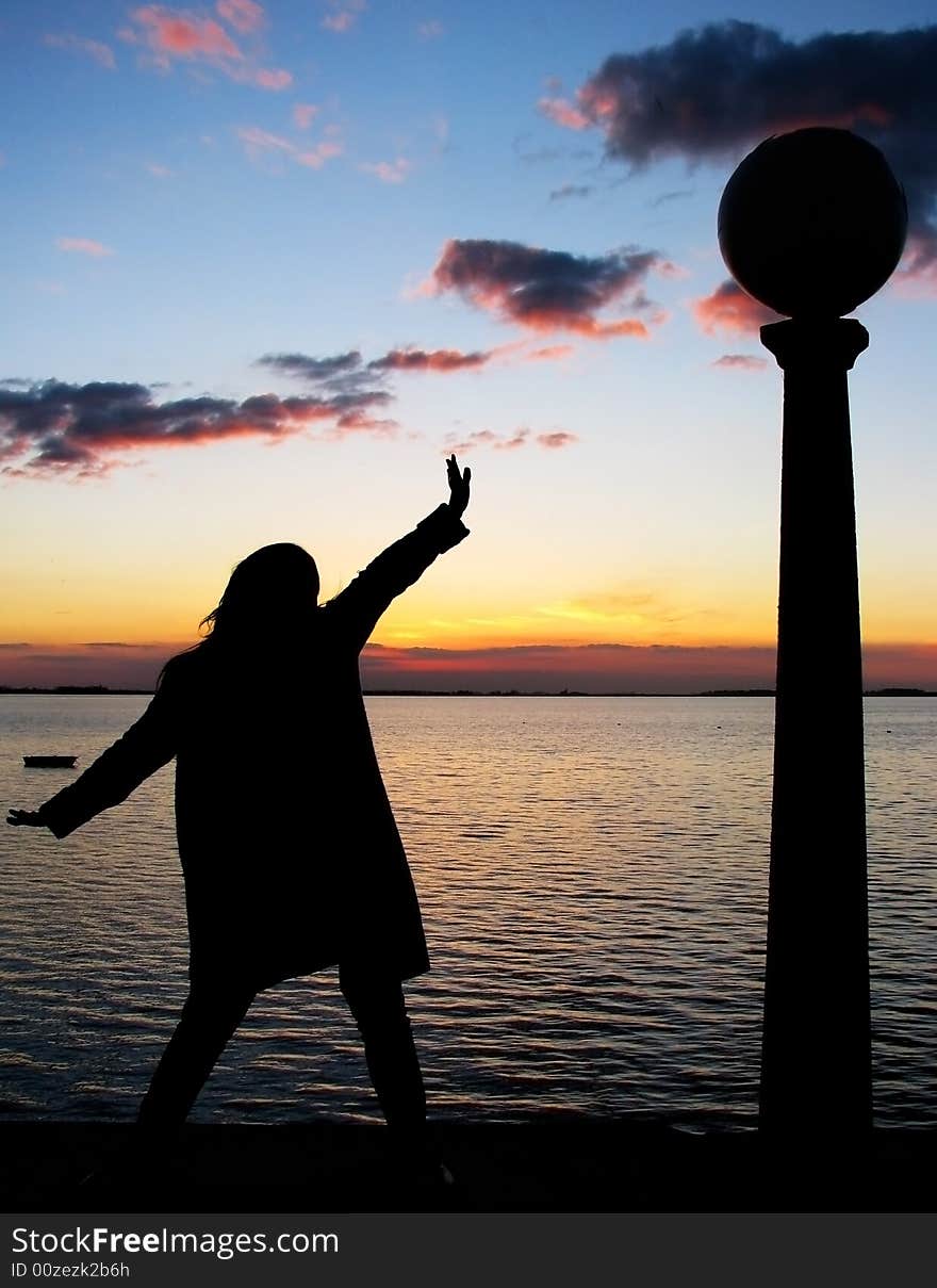 Woman silhouette against sunset background in the lake. Woman silhouette against sunset background in the lake.