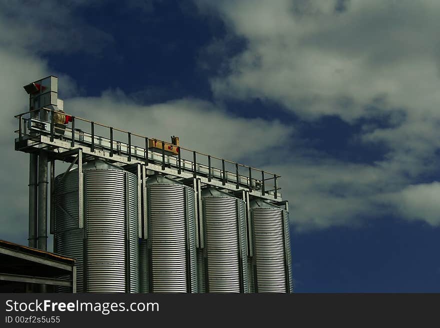 Four Brewery Grain Silos against a cloudy sky