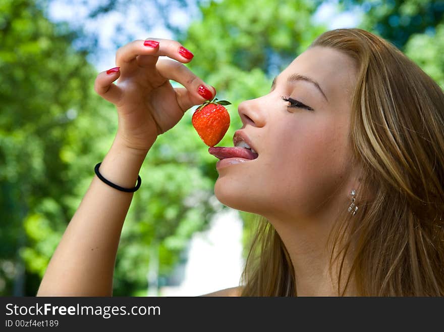 Portrait of the beautiful young girl with strawberry