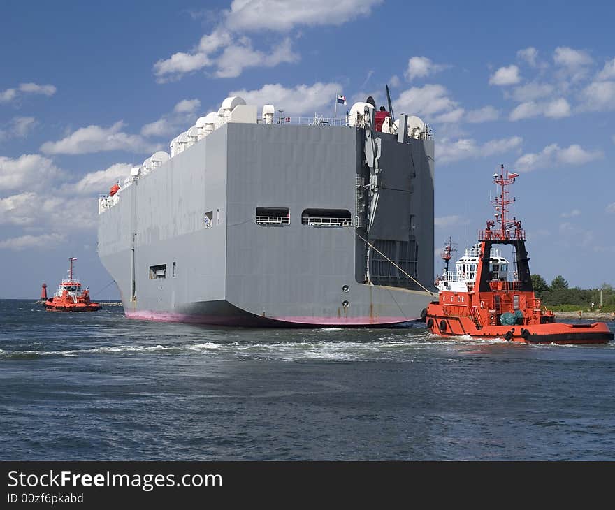 A tugboat assisting huge vessel