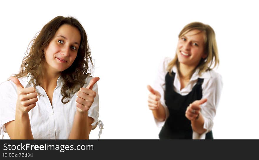 Two young pretty businesswomen colleagues are giving the thumbs up and they are smiling. They are wearing stylish shirts. Two young pretty businesswomen colleagues are giving the thumbs up and they are smiling. They are wearing stylish shirts.