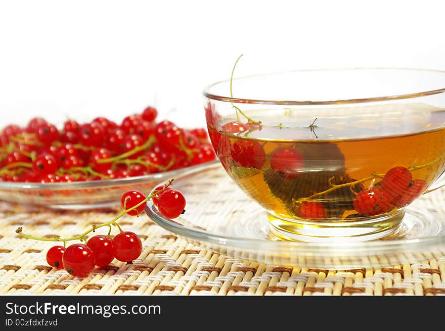 Red currant and herbal tea in a transparent cup