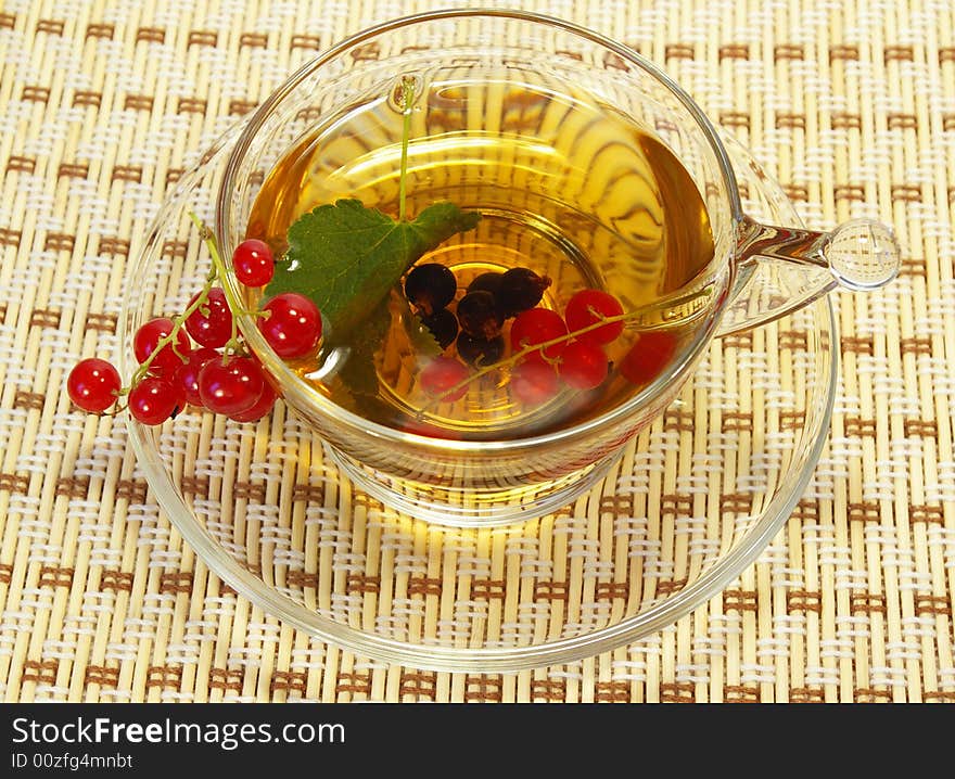 Red currant and herbal tea in a transparent cup