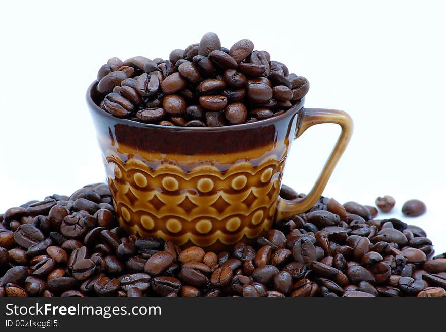 Cup with coffee beans isolated on the white background