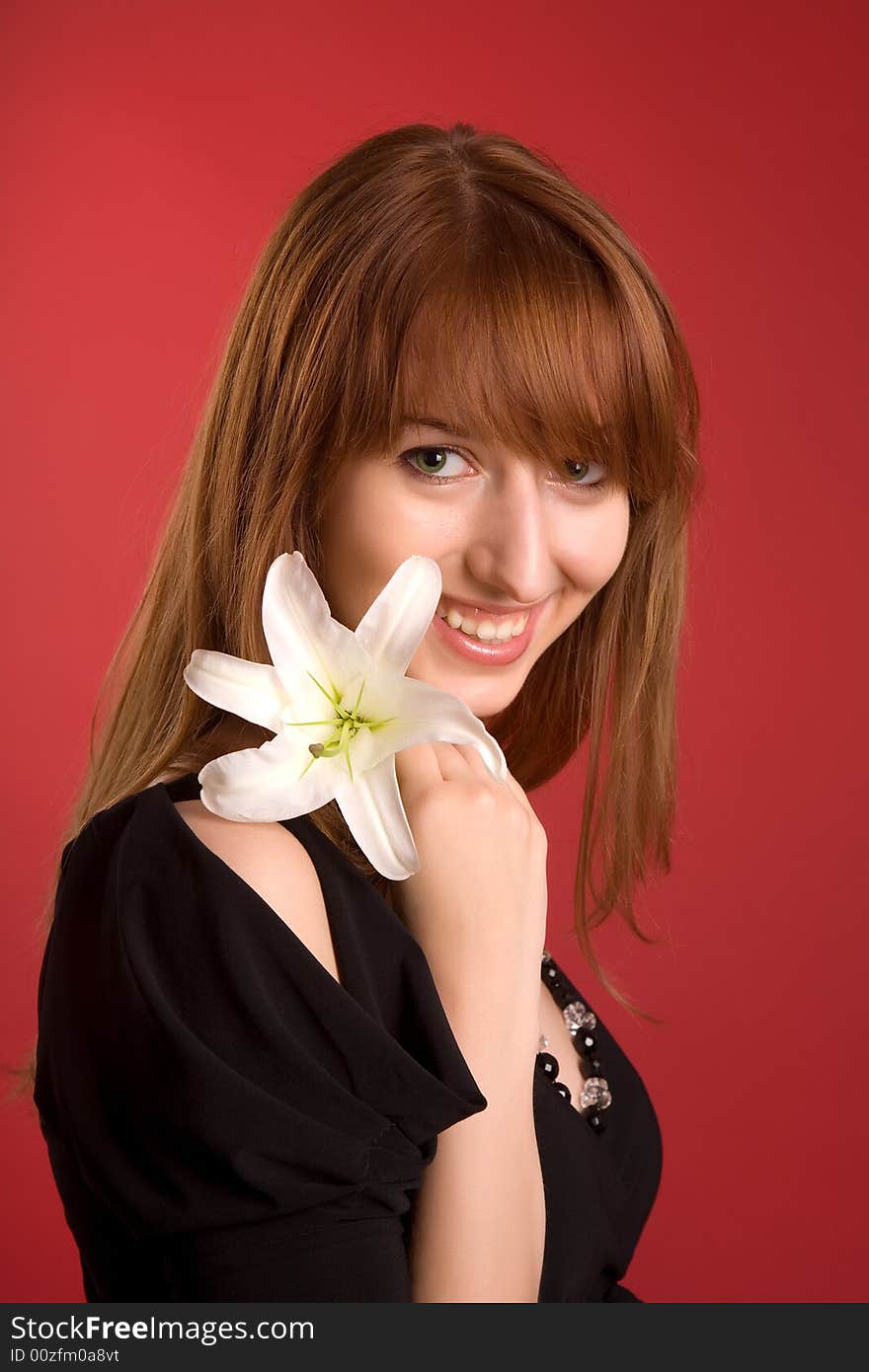 Laughing girl with flower isolated on red background