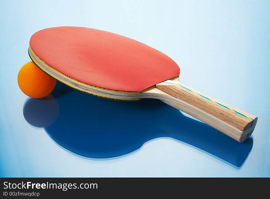 Tennis racket and orange ball on a blue background