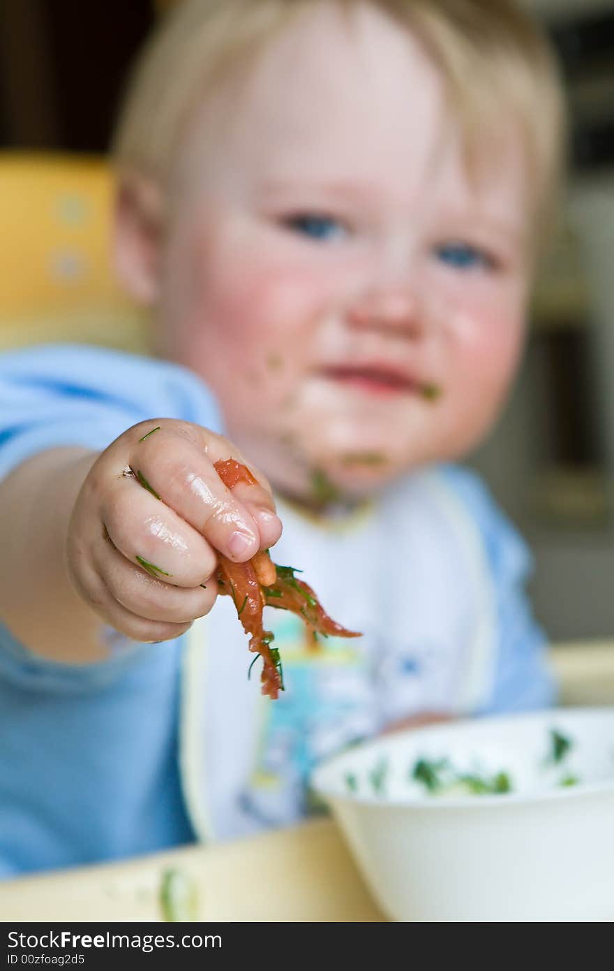 Laughing child soiled with salad