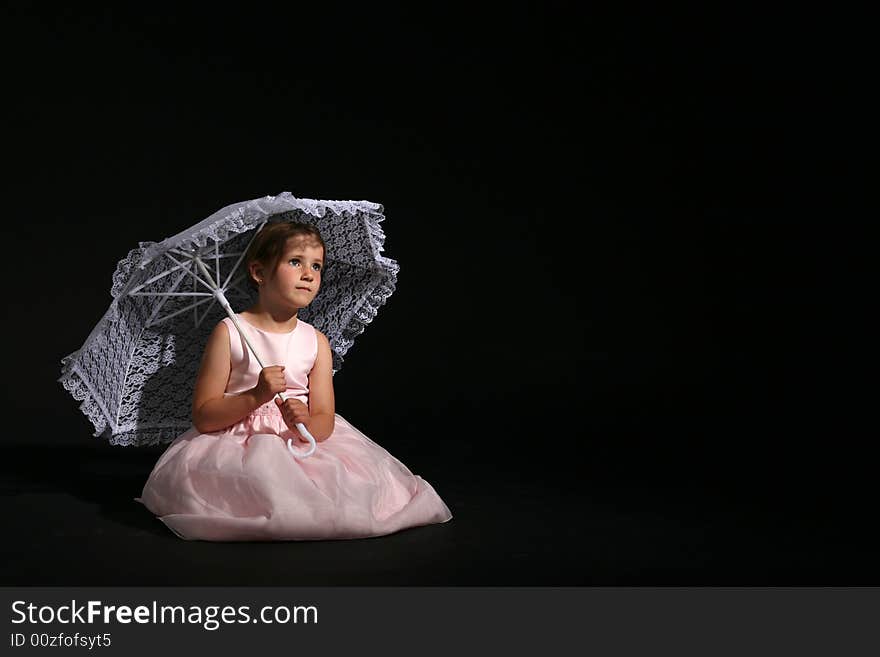 Little girl in a pretty pink dress and lacy parasol