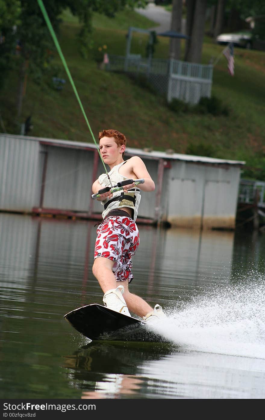 Teenage boy wakeboarding on the lake. Teenage boy wakeboarding on the lake