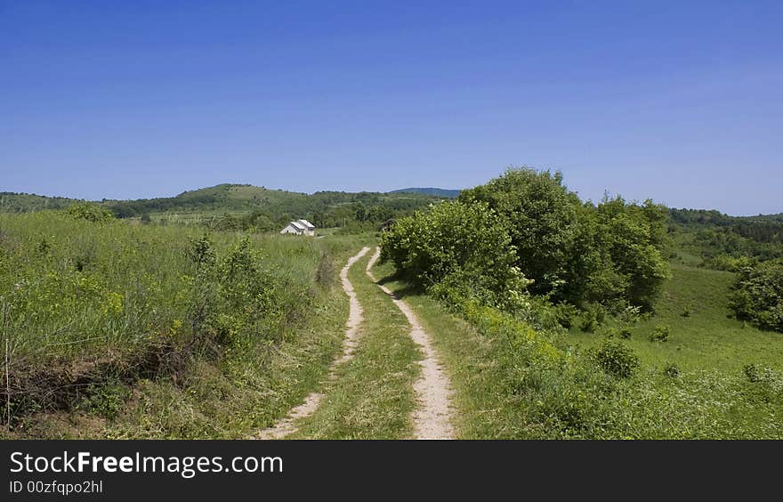 Landscape around Trojvrh village in Lika, Croatia. In the background is an abandoned building that used to be school. Landscape around Trojvrh village in Lika, Croatia. In the background is an abandoned building that used to be school