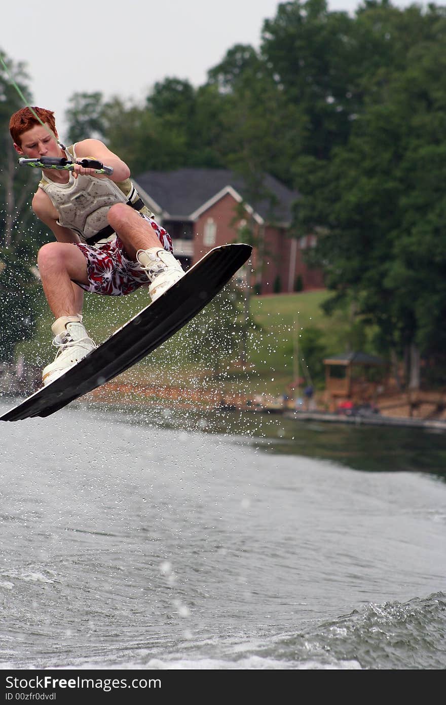 Teenage boy wakeboarding on the lake. Teenage boy wakeboarding on the lake