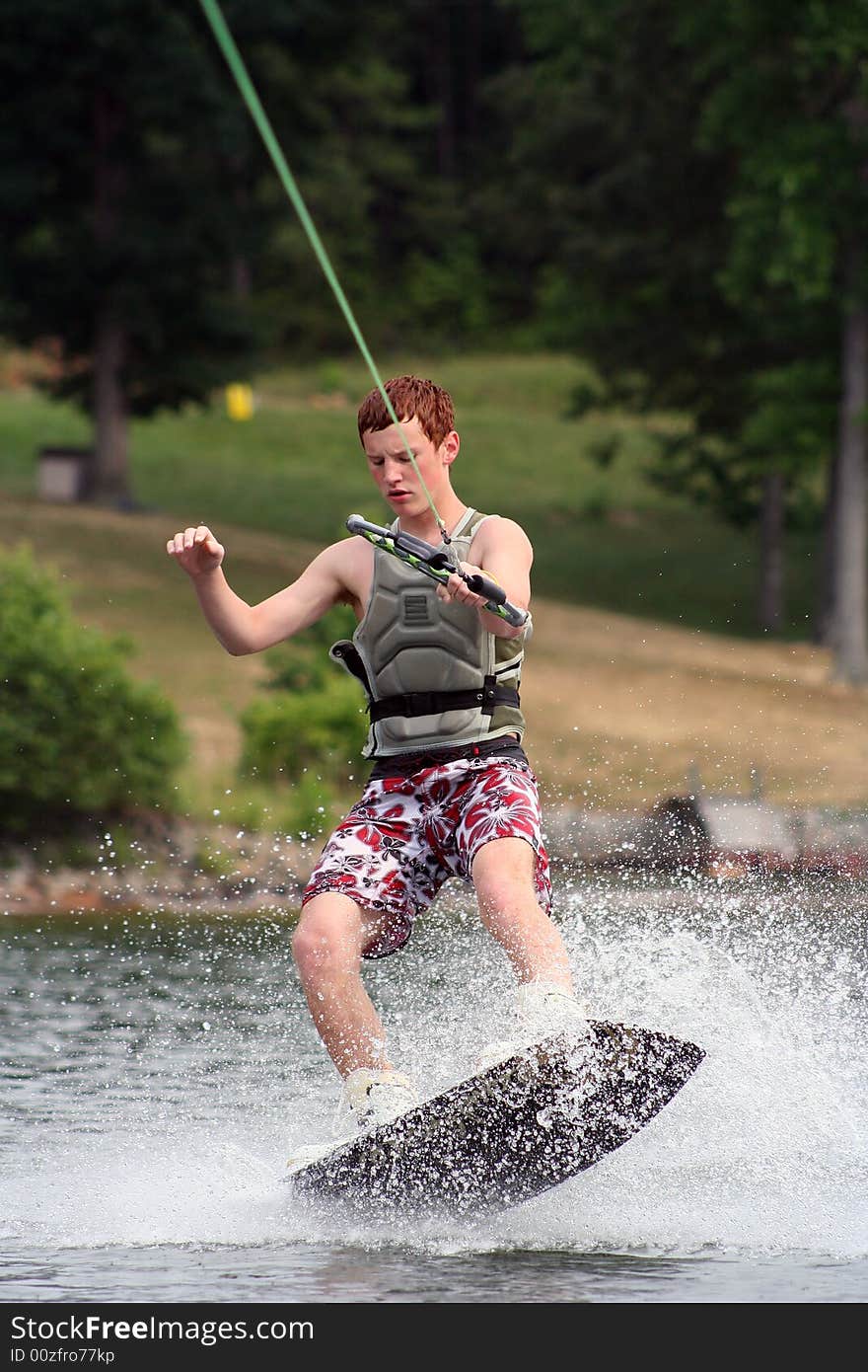 Teenage boy wakeboarding on the lake. Teenage boy wakeboarding on the lake