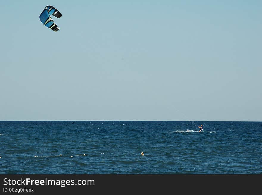 Kitesurfer on the blue mediterranean with a blue sky. Kitesurfer on the blue mediterranean with a blue sky