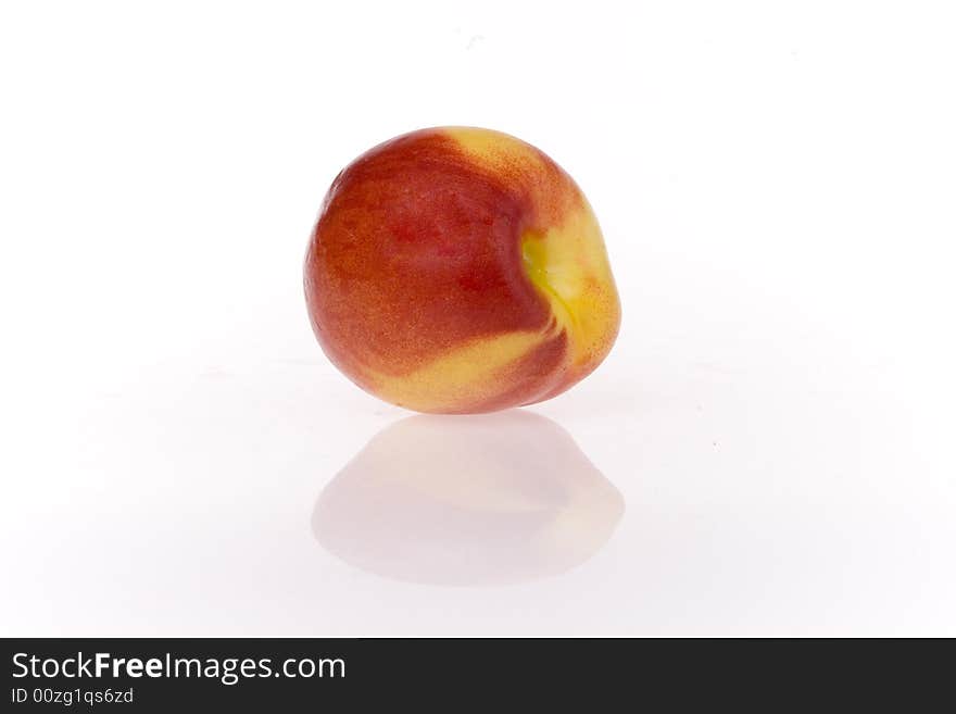 One sweet and juicy nectarine on white ground. One sweet and juicy nectarine on white ground