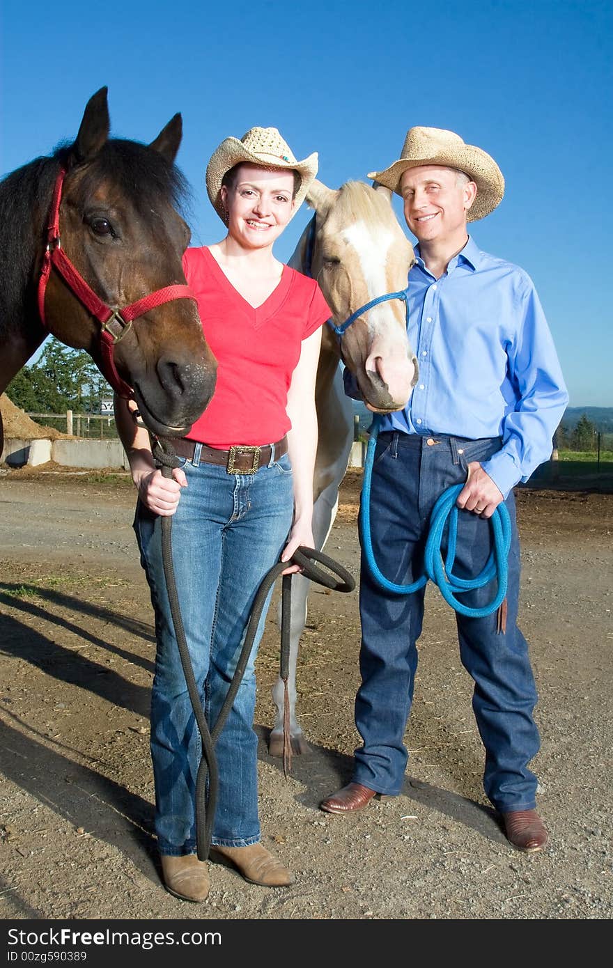 Man and Woman Stand With Horses - vertical