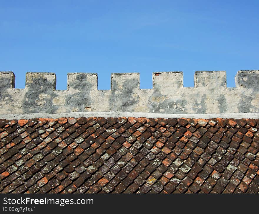 Old toothing fortress wall with red tiles