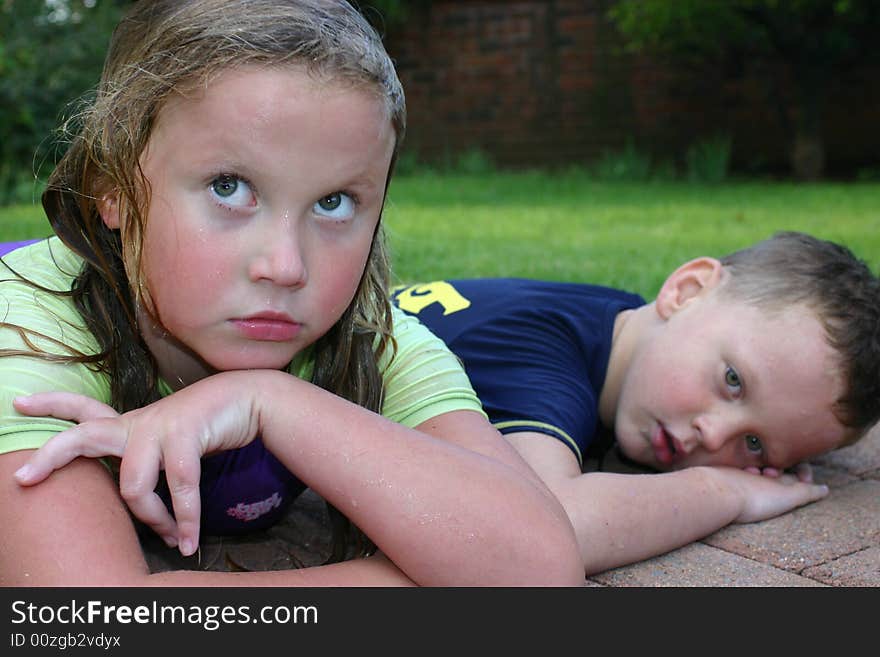 Brother and sister lying together after a lovely refreshing swim. Brother and sister lying together after a lovely refreshing swim.