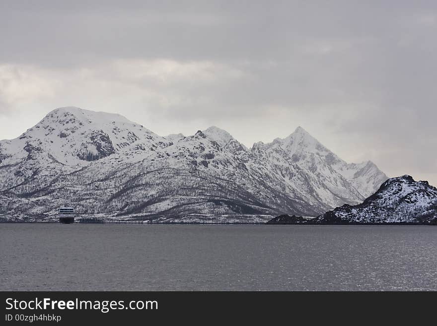 Ship and snow-covered mountains at the Arctic ocean. Ship and snow-covered mountains at the Arctic ocean