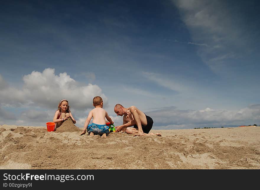 Dad and children having fun on the beach. Dad and children having fun on the beach